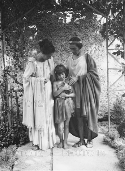 Kanellos, Vanellos and Tanagra, and child holding a cat, in dance costumes, 1929 Creator: Arnold Genthe.