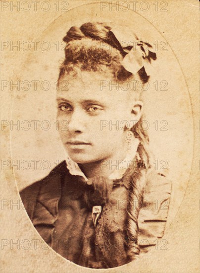 Oval portrait of unidentified young woman with long curl draped over chest. c1880-c1889. Creator: Unknown.