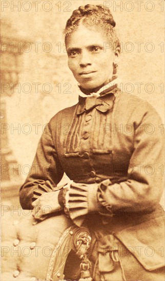 Studio portrait of unidentified woman, arms on back of chair, c1880-c1889. Creator: Richmond Photograph Co.