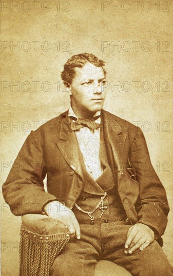 Studio portrait of unidentified seated young man, his left arm resting on chair, c1870-c1879. Creator: Unknown.