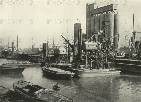 Factories, Refineries, Granaries Grow Thick Ship Discharging Grain by Floating Pneumatic...', 1937 Creator: J Dixon-Scott.