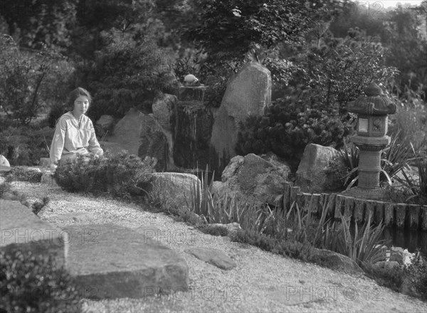 Unidentified woman seated in a garden next to a stream, possibly belonging to A.W. Bahr, c 1917-1934 Creator: Arnold Genthe.