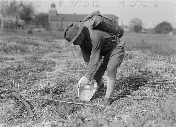 Leonard D. Mahon with steel helmet he invented that could be used as shovel, 1917. Creator: Harris & Ewing.