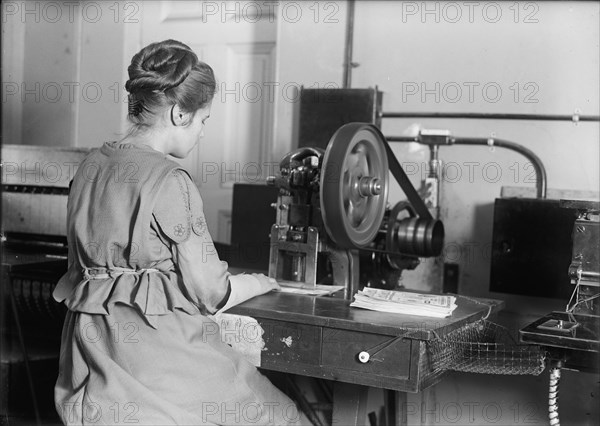 Seal of The United States - Stamping Bonds, 1917. Creator: Harris & Ewing.