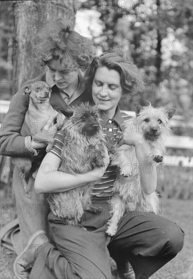 Le Gallienne, Eva, and unidentified woman, with dogs, outdoors, 1937 Creator: Arnold Genthe.