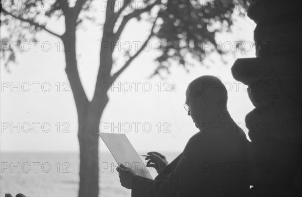 Bruce, Ned, Mr., reading and writing outdoors, 1915? Creator: Arnold Genthe.