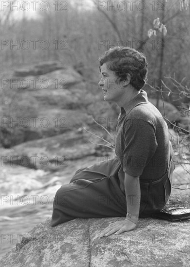 DeLamar, Alice, Miss, seated on a rock, between 1927 and 1942. Creator: Arnold Genthe.