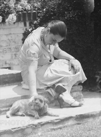 Manship, Pauline, Miss, with dog, seated outdoors, 1931 June 14. Creator: Arnold Genthe.