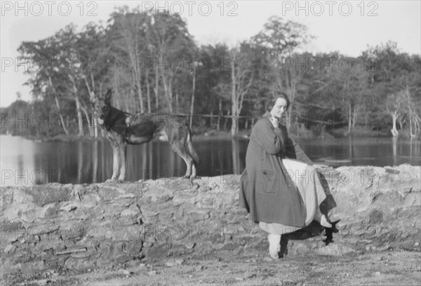 Mower, Margaret, Miss, with dog, seated outdoors, not before 1916. Creator: Arnold Genthe.