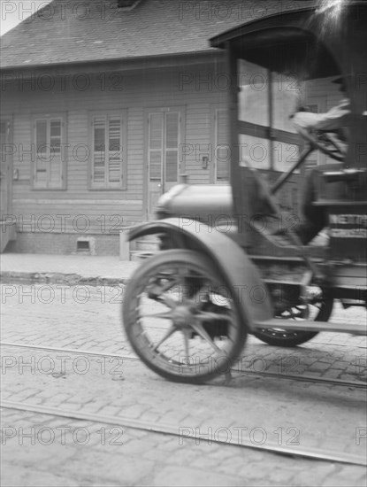 Car driving down a street, New Orleans or Charleston, South Carolina, between 1920 and 1926. Creator: Arnold Genthe.