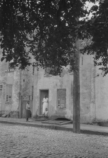 Woman and children standing in or by a doorway, [17 Chalmers Street], Charleston..., c1920-c1926. Creator: Arnold Genthe.