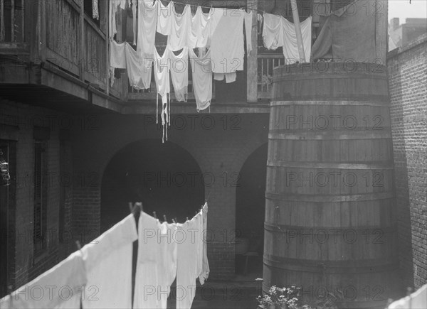 Courtyard with cistern and hanging laundry, New Orleans, between 1920 and 1926. Creator: Arnold Genthe.