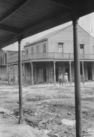 Two men crossing an unpaved street, New Orleans or Charleston, South Carolina, between 1920 and 1926 Creator: Arnold Genthe.