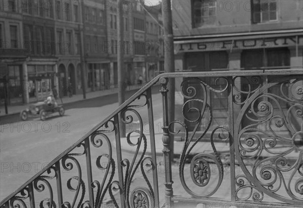 Street seen from behind the wrought iron railing of the Market Hall, Charleston..., c1920-c1926. Creator: Arnold Genthe.