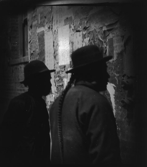 Reading wall notices, Chinatown, San Francisco, between 1896 and 1906. Creator: Arnold Genthe.