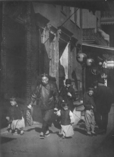 Man and two boys walking along a street, Chinatown, San Francisco, between 1896 and 1906. Creator: Arnold Genthe.