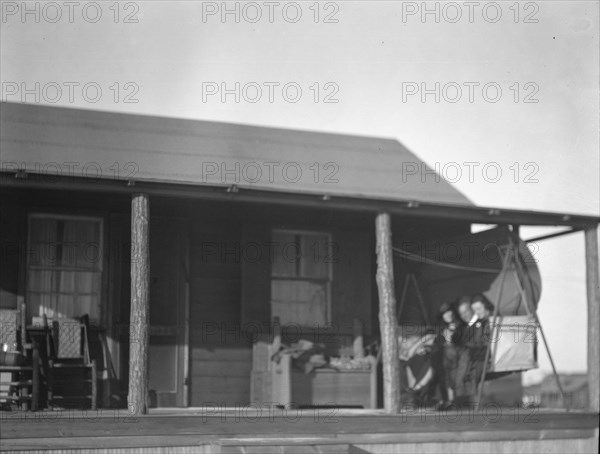 Arnold Genthe and two women friends seated on a swing on the porch of his...New York, c1911-c1942. Creator: Arnold Genthe.