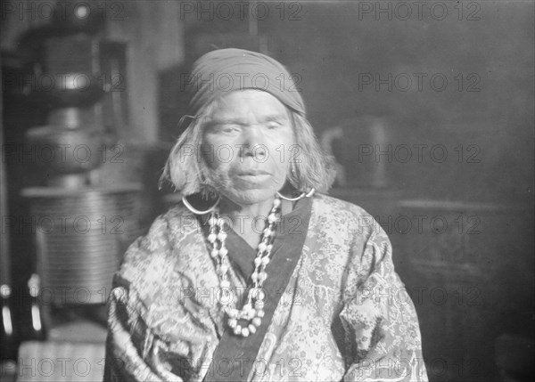 Ainu woman wearing a headscarf, earrings, and a necklace, 1908. Creator: Arnold Genthe.