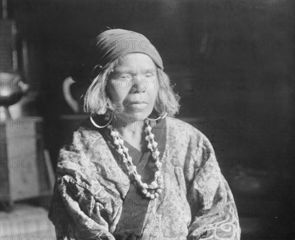 Ainu woman wearing a headscarf, earrings, and a necklace, 1908. Creator: Arnold Genthe.