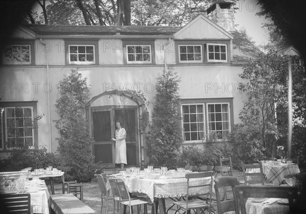 Mrs. Mary Benson standing at the entrance to her house, between 1933 and 1942. Creator: Arnold Genthe.