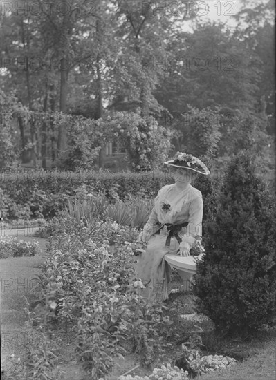 Truesdale, W., Mrs., standing in a garden, 1915 July 6. Creator: Arnold Genthe.