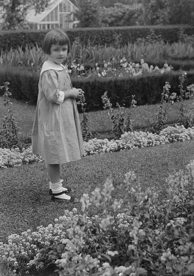 Truesdale, Virginia, Miss, standing in a garden, 1915 July 21. Creator: Arnold Genthe.