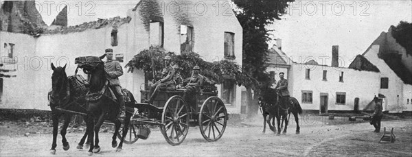 'Des equipages allemands traversent, pres de Vise, le village de Mouland incendie', 1914. Creator: Vereenigde Fotobureaux Amsterdam.