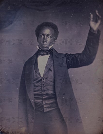 Edward J. Roye, three-quarter length portrait, standing, with hand raised, between 1856 and 1858. Creator: Augustus Washington.