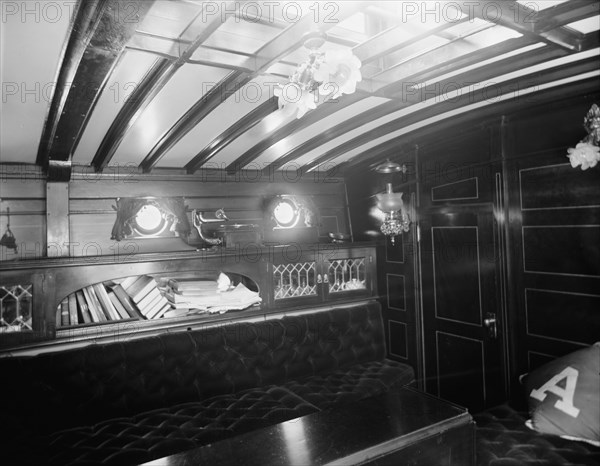 Yacht Althea, cabin, showing books, between 1907 and 1915. Creator: Unknown.