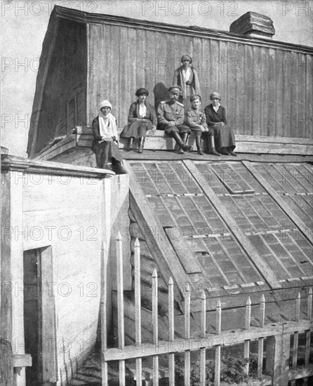 ''Les Romanof a Tobolsk; Le tsar et ses enfants venus chercher sur la toiture d'une serre..., 1917. Creator: Unknown.