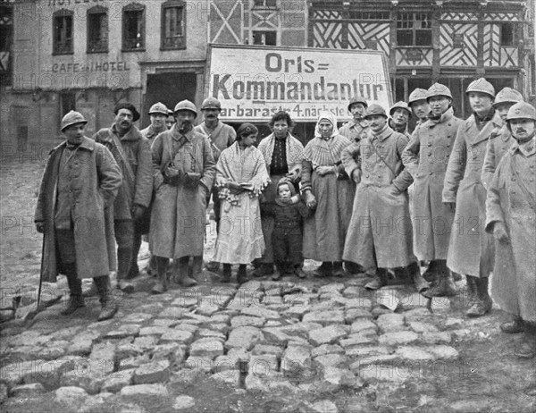 'En territoire libere; Dans Roye delivre le 17 mars: soldats et habitants devant l'ecriteau decroche Creator: Unknown.