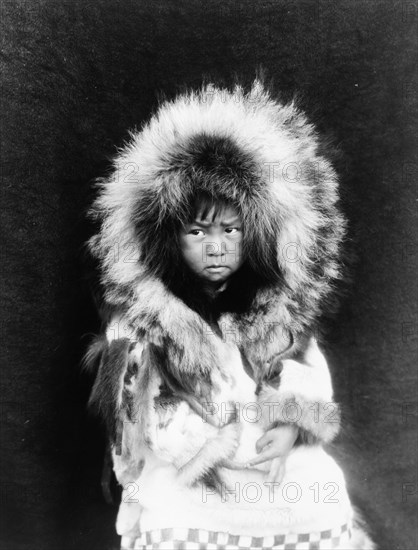 Noatak child, three-quarter length portrait, seated, facing front, c1929. Creator: Edward Sheriff Curtis.