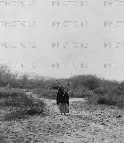 Pima woman, with burden basket on back, walking away from camera, Pima, Arizona, c1907. Creator: Edward Sheriff Curtis.