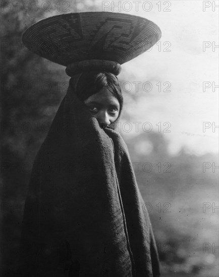 Maricopa girl, half-length portrait, standing, facing slightly right, wrapped in blanket..., c1907. Creator: Edward Sheriff Curtis.