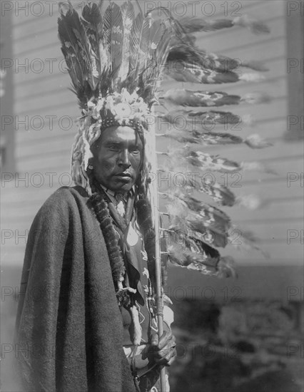 Piegan war-bonnet and coup-stick, c1910. Creator: Edward Sheriff Curtis.