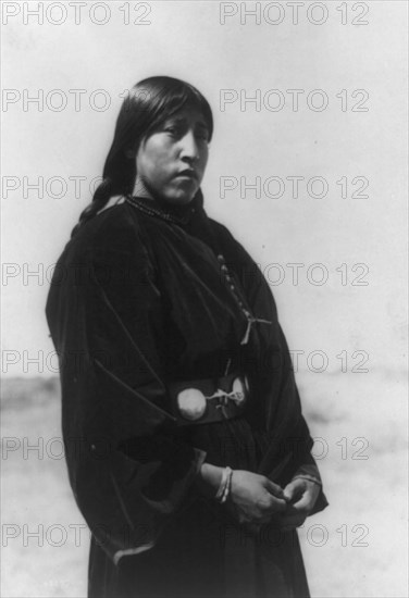 Arapaho maiden, three-quarter-length portrait, standing, facing right, c1910. Creator: Edward Sheriff Curtis.