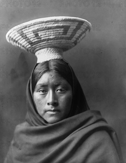 Papago Indian, Luzi, head-and-shoulders portrait, facing front, with a basket tray on her head,c1907 Creator: Edward Sheriff Curtis.