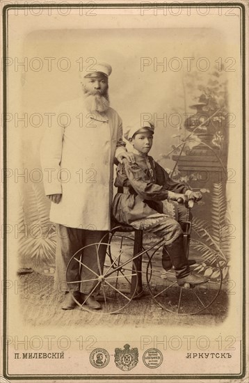 Portrait of an unknown man with a boy sitting on a bicycle, end of 19th century. Creator: PA Milevskii.