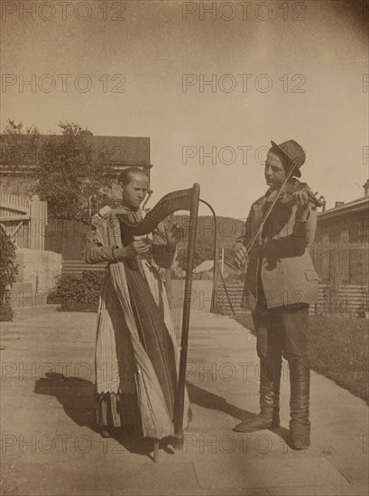 Street musicians with a harp and violin in the upper yard of Dom Smith, Vladivostok, Russia, (1899?) Creator: Eleanor Lord Pray.