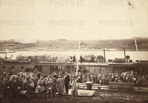 Party of exiles and convicts embarking on river barge at Tumen [ie, Tiumen]..., between 1885 and 86. Creator: Unknown.