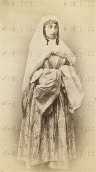 Full-length portrait of a woman, facing slightly right, in traditional dress, between 1870 and 1886. Creator: Unknown.