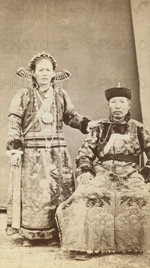 Full-length portrait of wealthy Buriat man and his wife, facing front, between 1870 and 1886. Creator: Unknown.