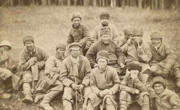 Group portrait of convicts seated in a field, between 1880 and 1886. Creator: Unknown.