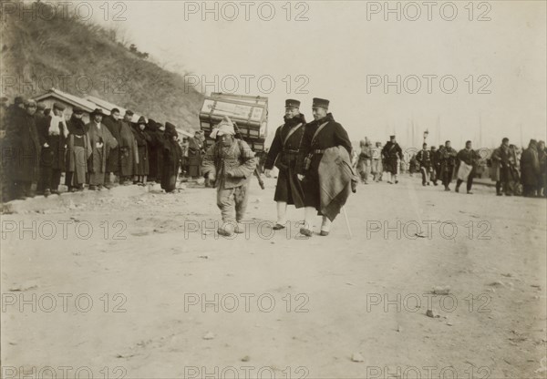 A Korean coolie carrying medical supplies from shore to hospital at Chemulpo, c1904. Creator: Robert Lee Dunn.