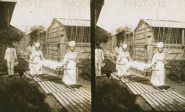 Japanese nurses carrying a patient on a stretcher, c1905. Creator: Underwood & Underwood.