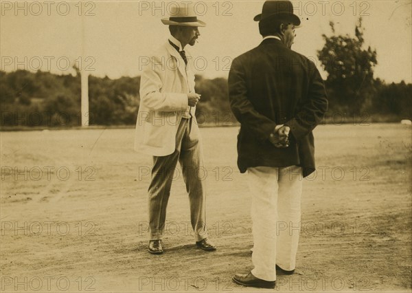Two men, probably journalists, standing on a field, 1905. Creator: Unknown.