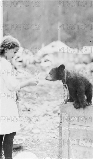 Girl and bear cub, between c1900 and 1916. Creator: Unknown.