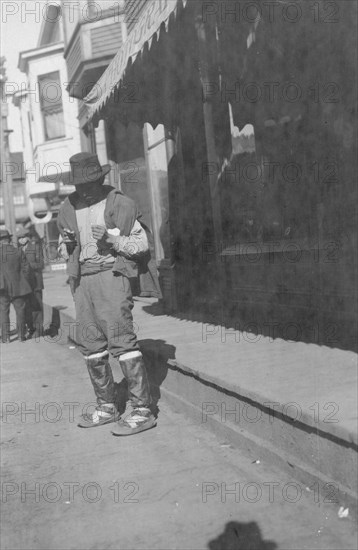 Man outside store, between c1900 and 1916. Creator: Unknown.