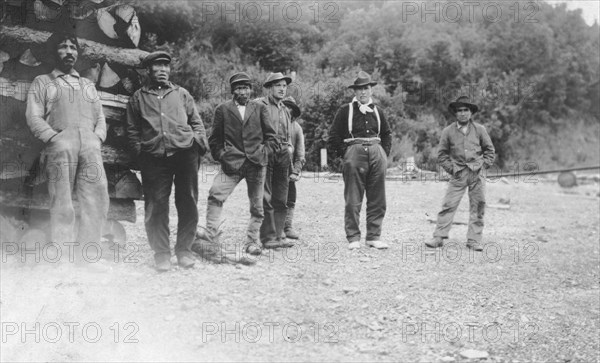 Men next to logs, between c1900 and 1916. Creator: Unknown.