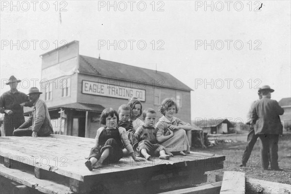 Children outside Eagle Trading Company, between c1900 and 1916. Creator: Unknown.